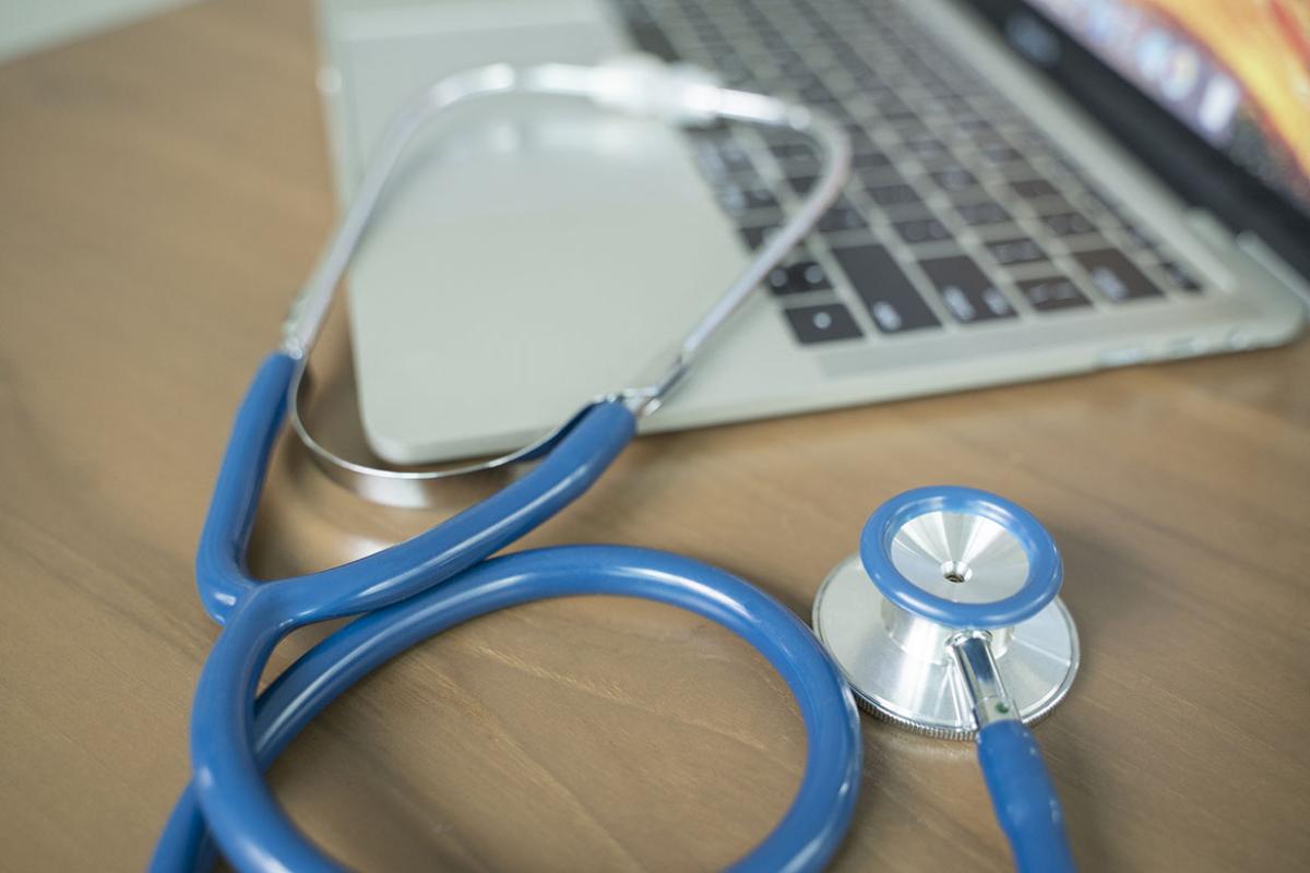 Stethoscope next to a laptop