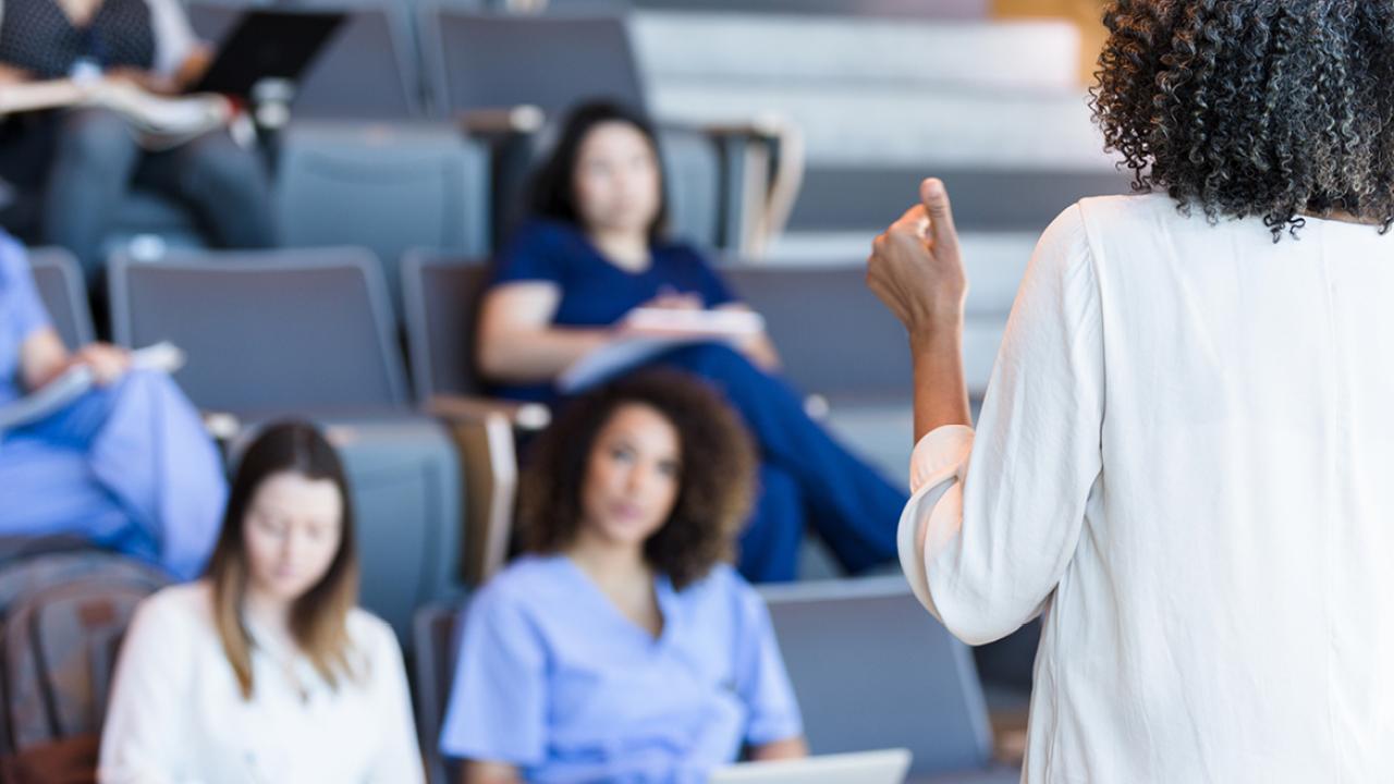 Teacher giving a lecture to a room of female students