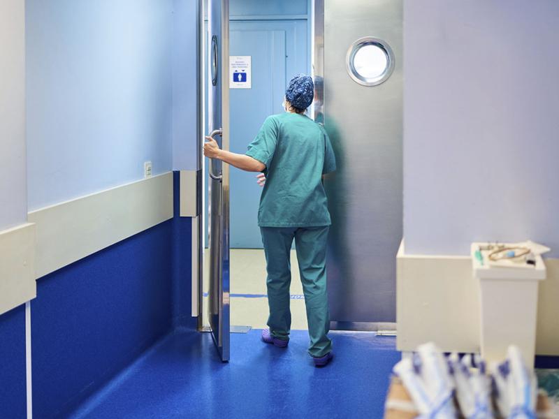 Health care worker opening a door in a hospital