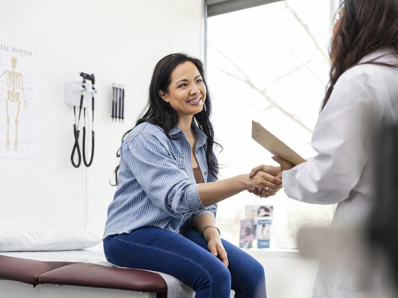 Smiling patient shaking hands with physician
