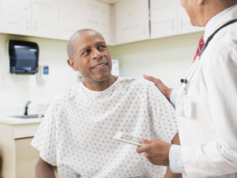 Smiling patient with physician's hand on his shoulder