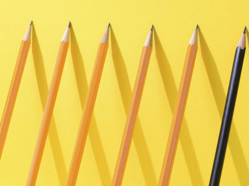 A row of pencils lined up on a wall