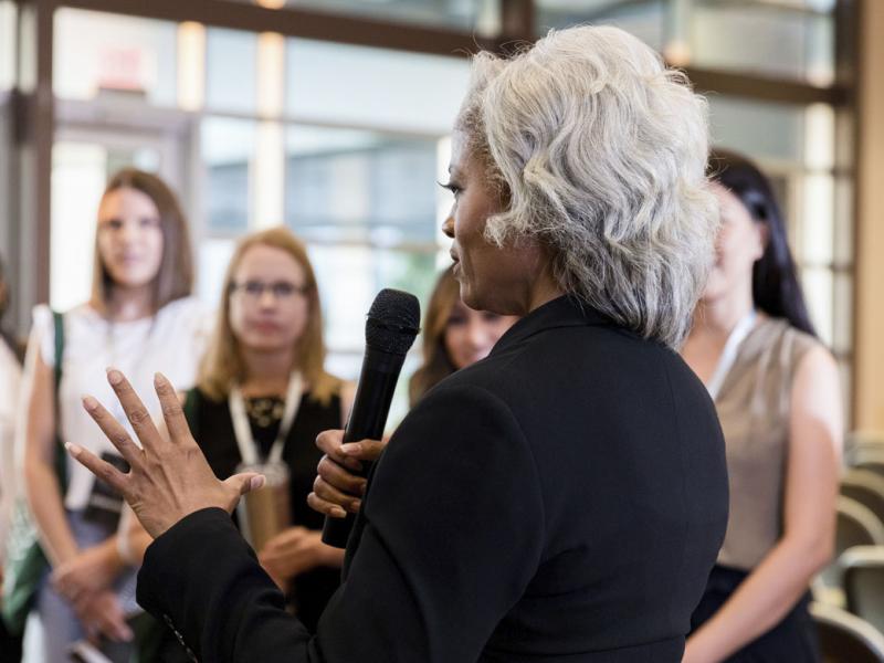 Person gestures while speaking to a crowd of people