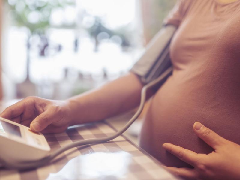 Pregnant person checking blood pressure at home