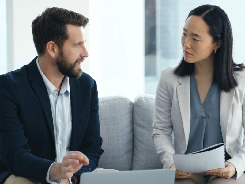 Two people in professional attire in conversation