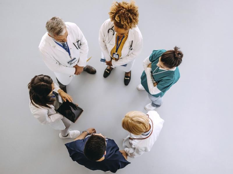 Health care workers standing in a circle while in discussion