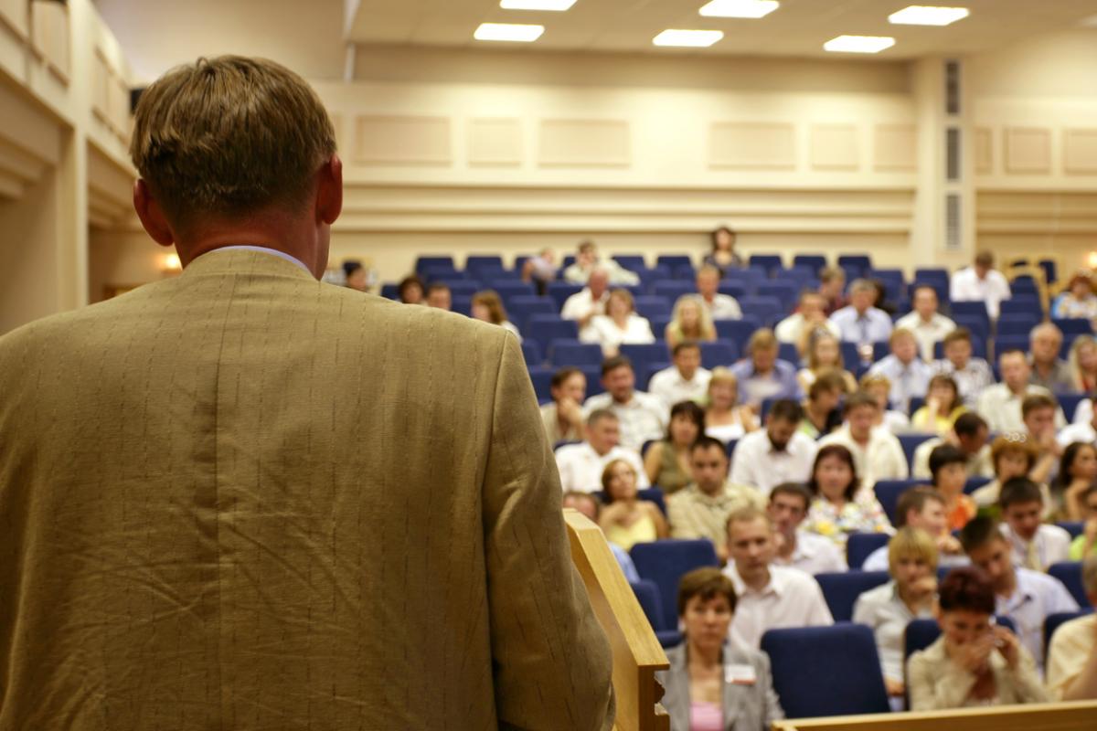 Physician presenting to a crowded auditorium