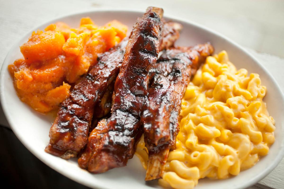 Plate heaping with bbq ribs, macaroni and cheese
