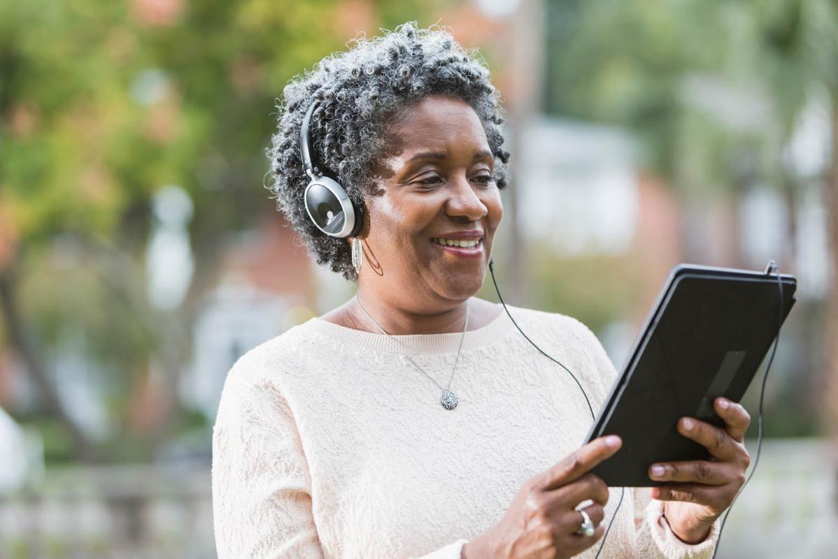 Woman in headphones looking at computer tablet