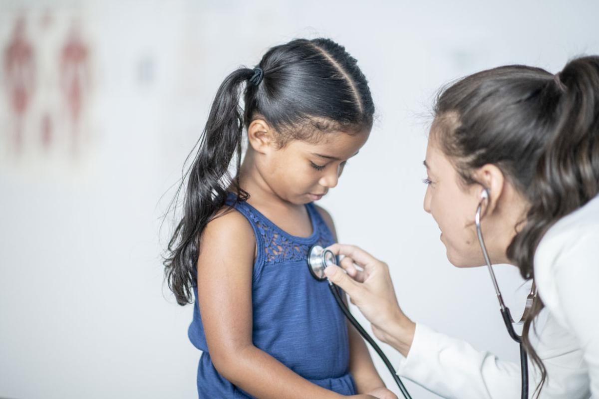 A physician listens to a girl's heartbeat with a stethoscope