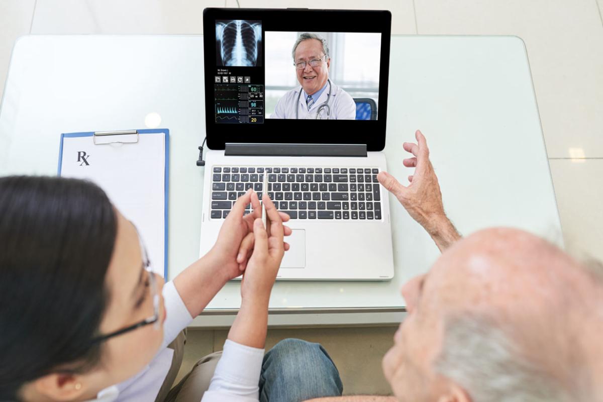 A physician consults with two patients through their laptop