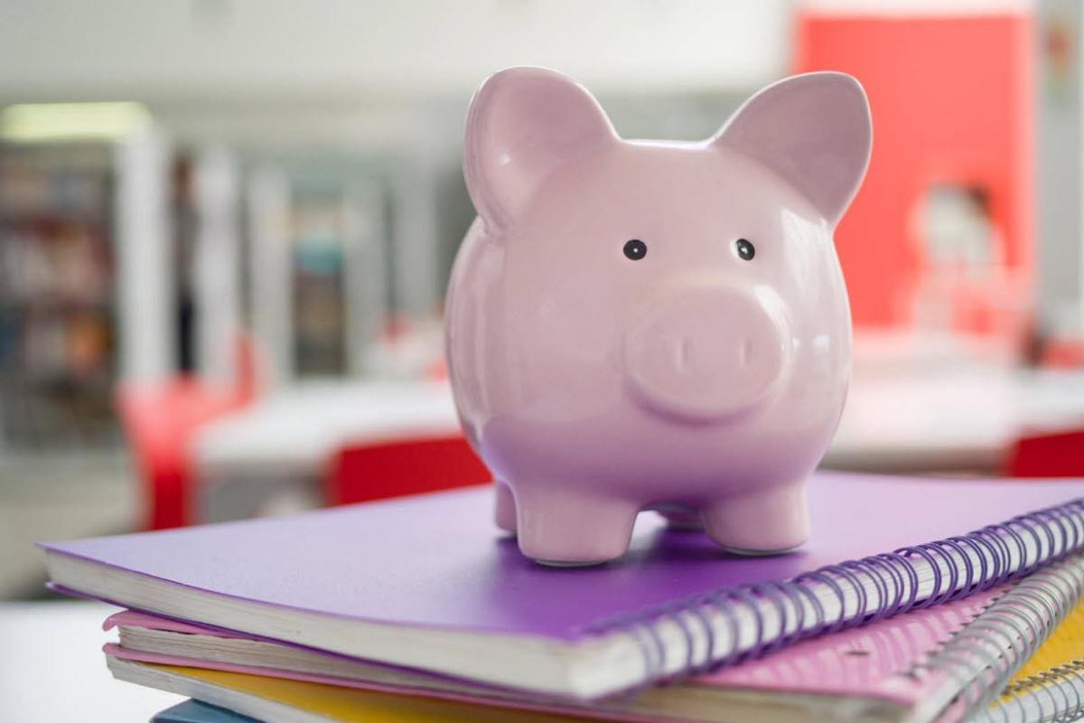 Piggy bank on top of some notebooks