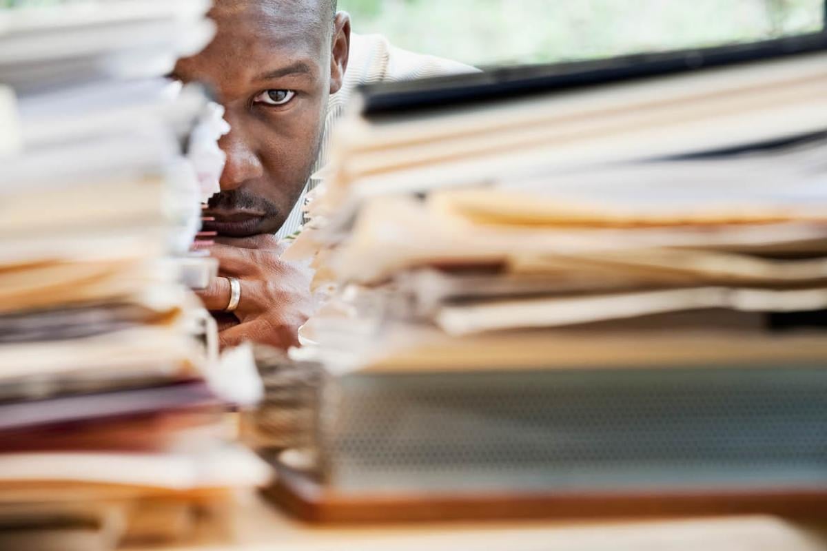 Man staring at a large stack of papers