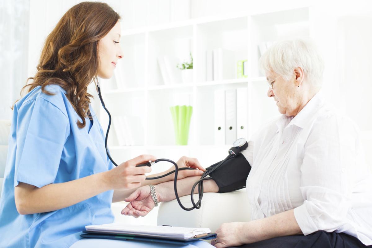 Health care worker measuring patient's blood pressure