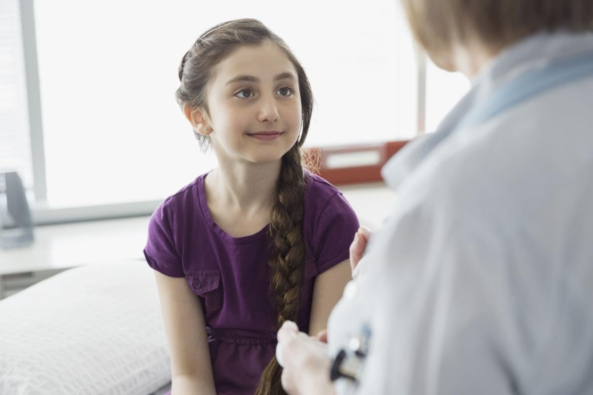 Little girl looking at her doctor