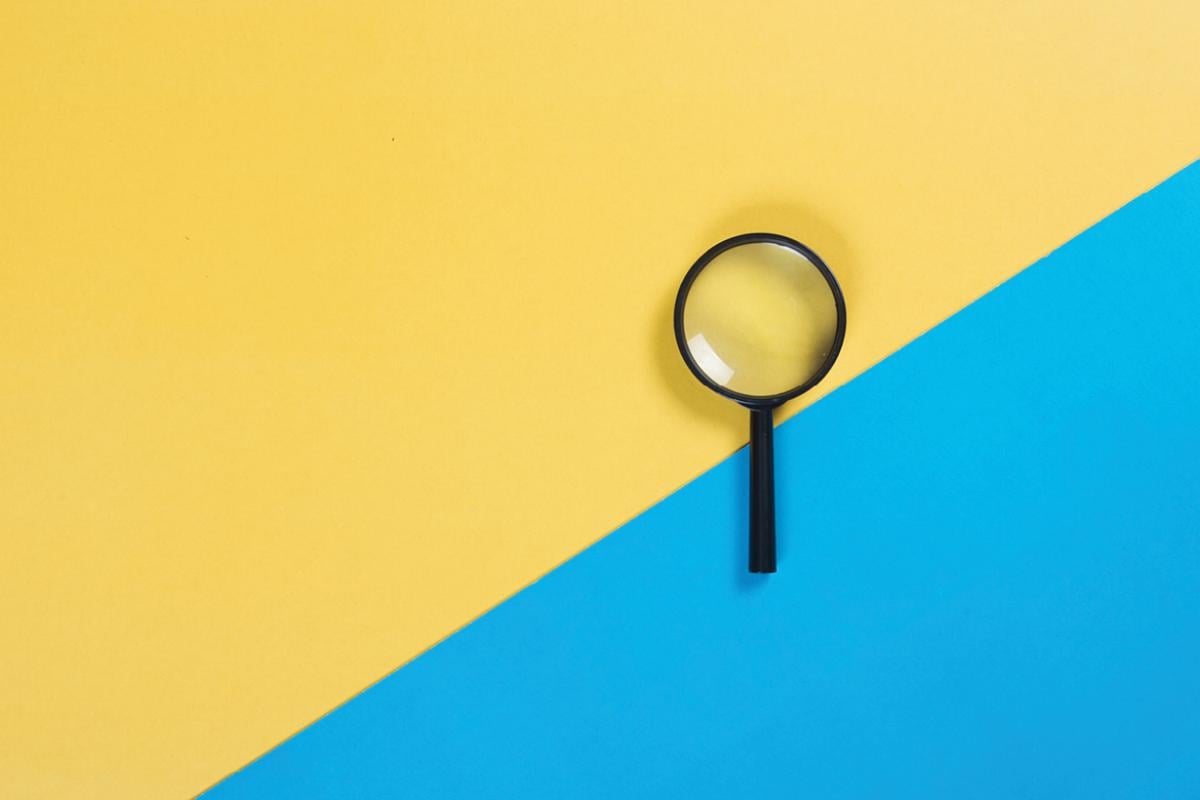 Magnify glass on blue and yellow background