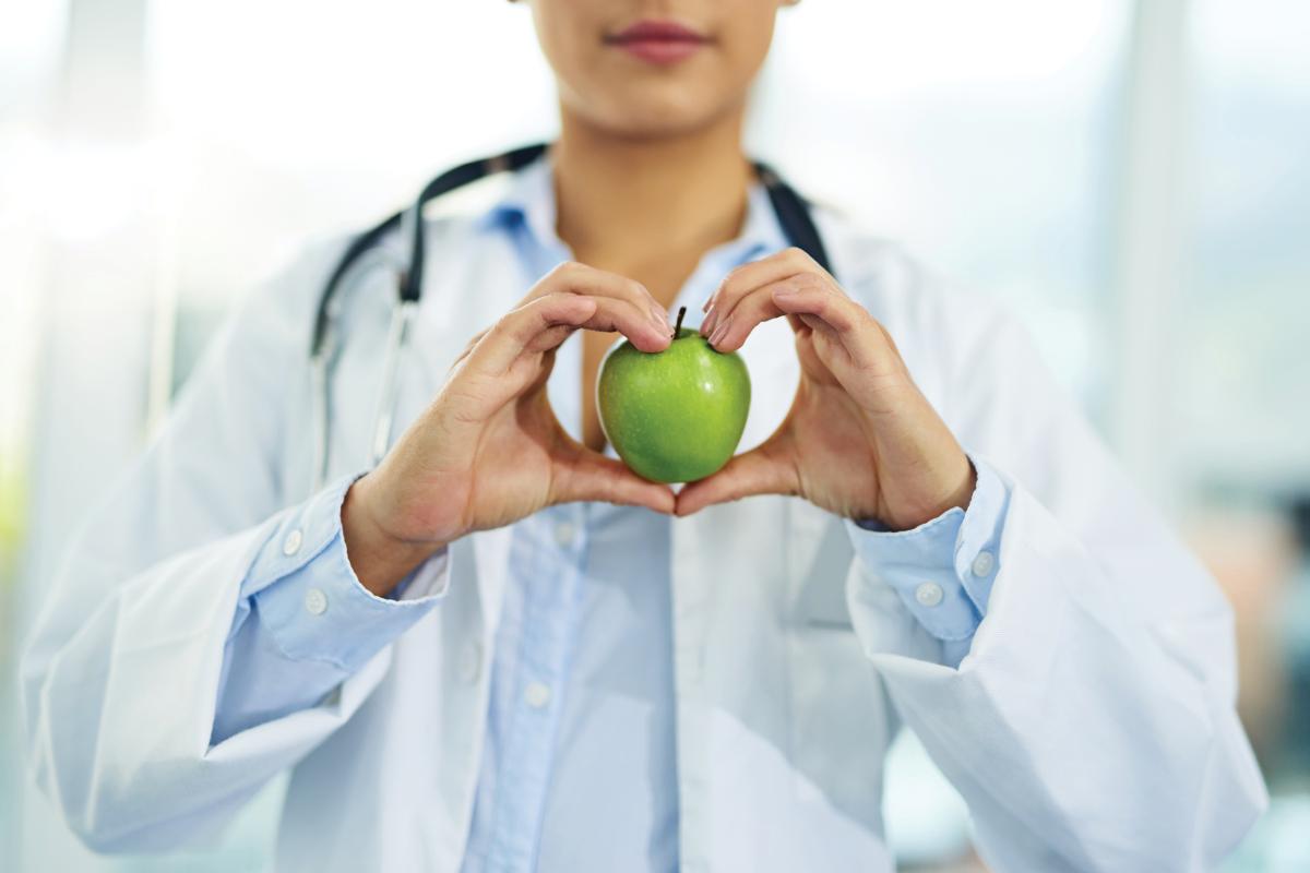 Physician holding a green apple