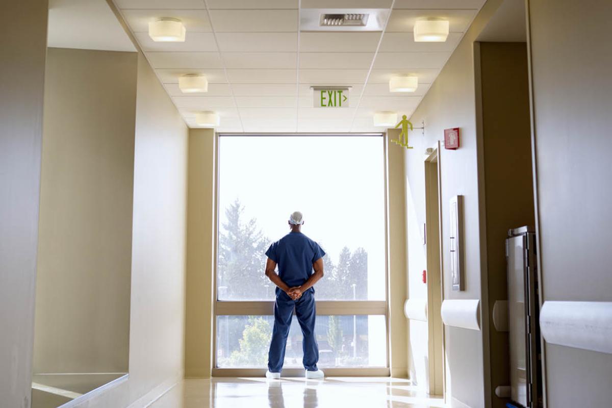 Health care worker looking out a window