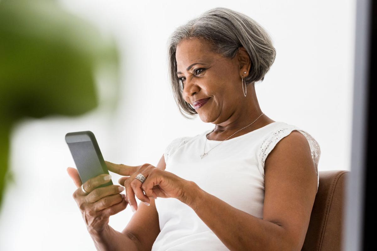 Woman staring down at mobile device.