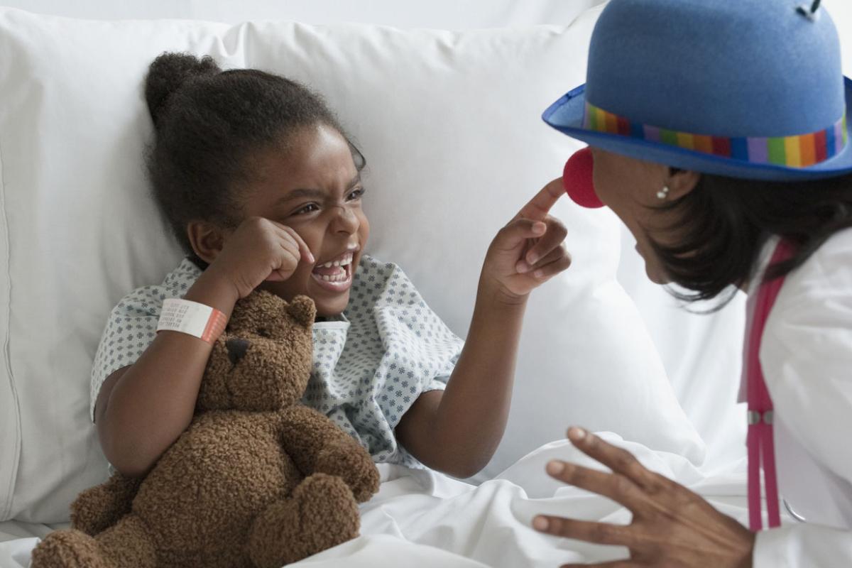 Young smiling patient pointing at a clown's nose