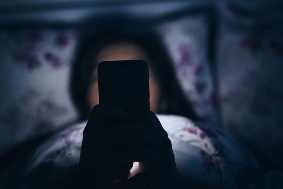 Person in bed using smartphone