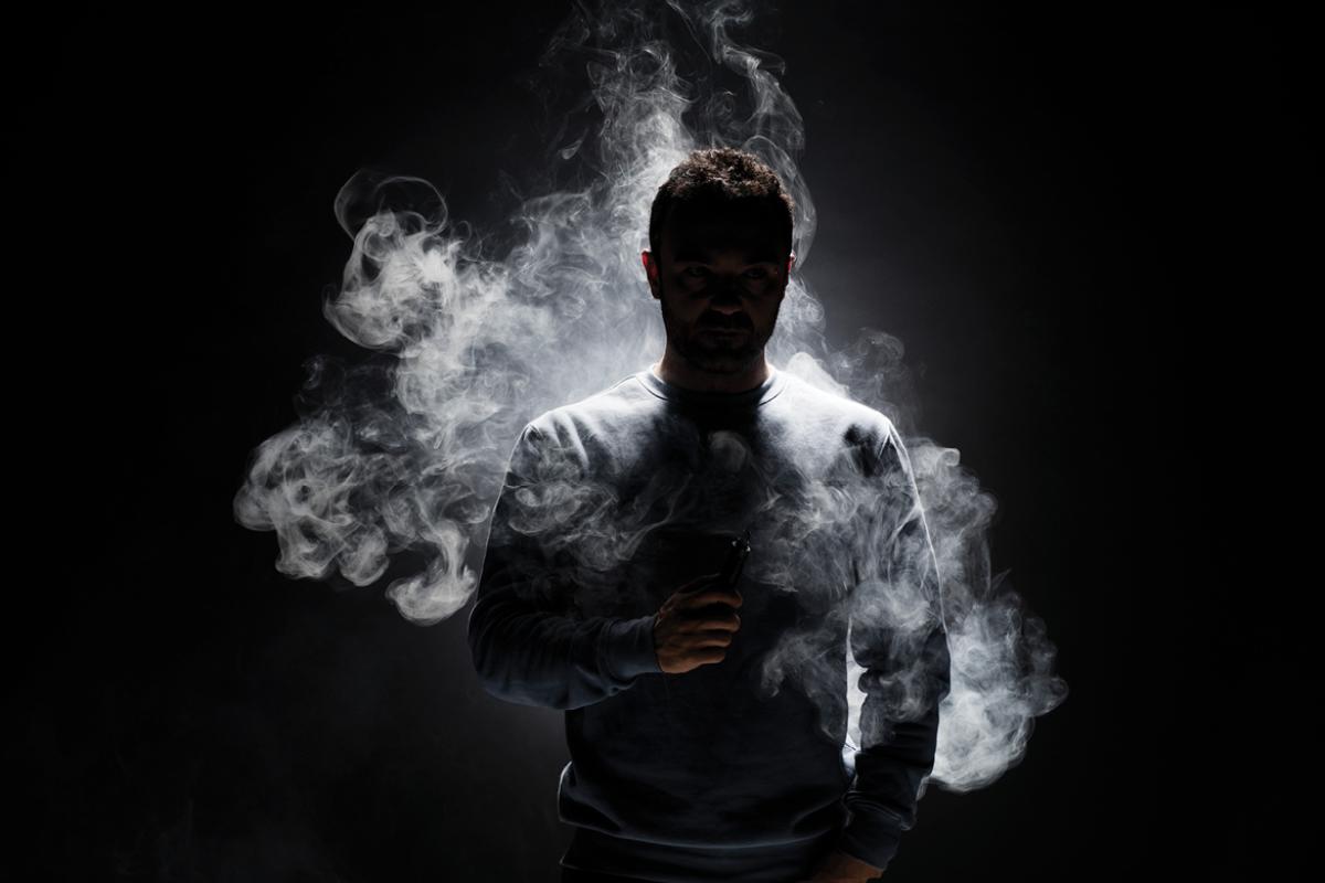 Human figure surround by smoke fragments on a black background.