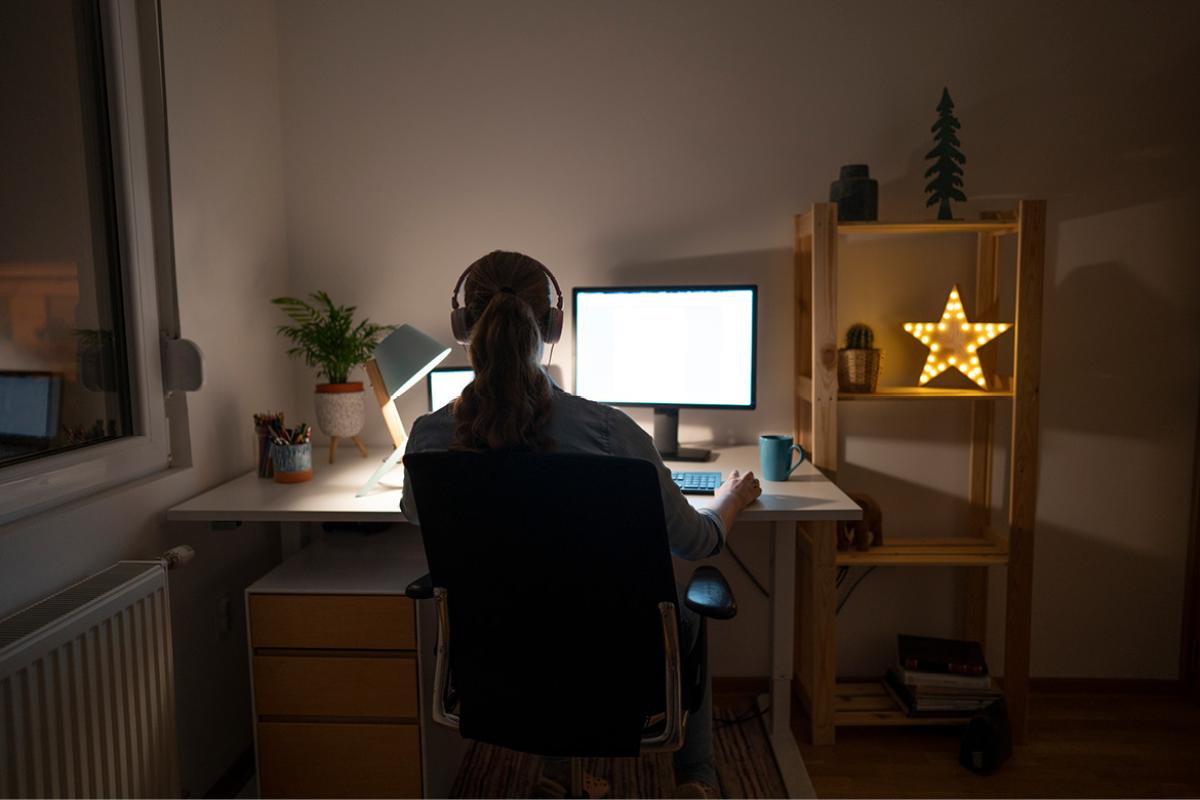 Person working in front of a computer in a dimmed room