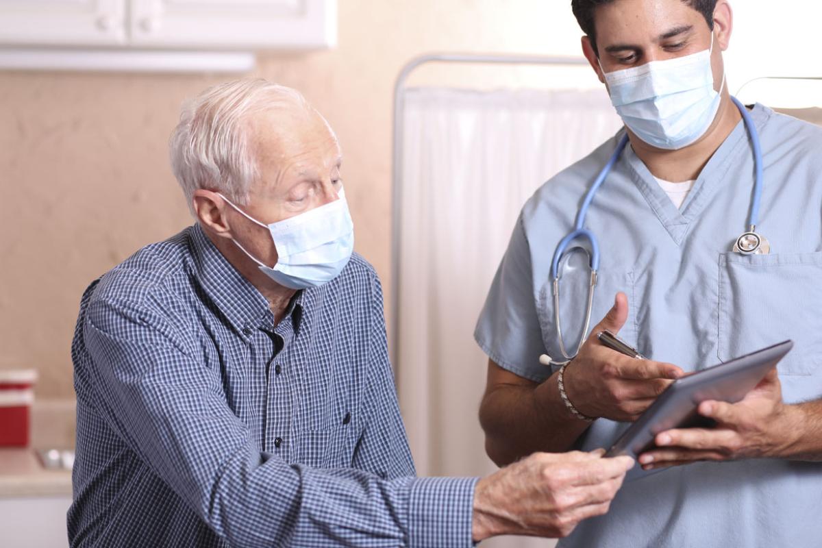 Patient and health care worker looking at a tablet.