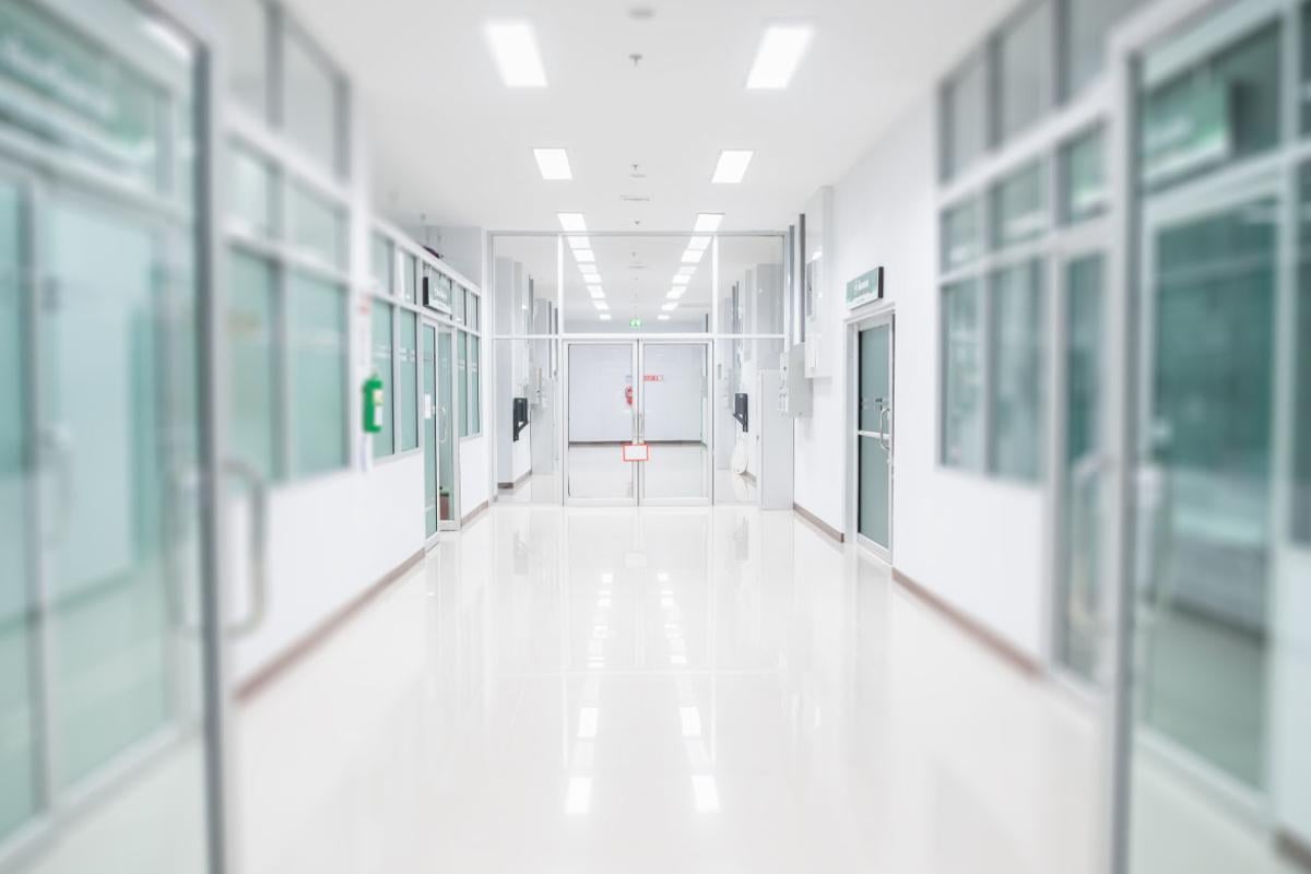 Long empty hospital corridor with closed doors at the end