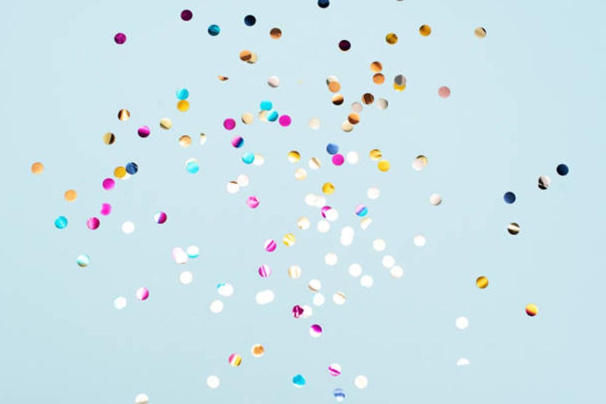 Different colors of confetti against a blue background.
