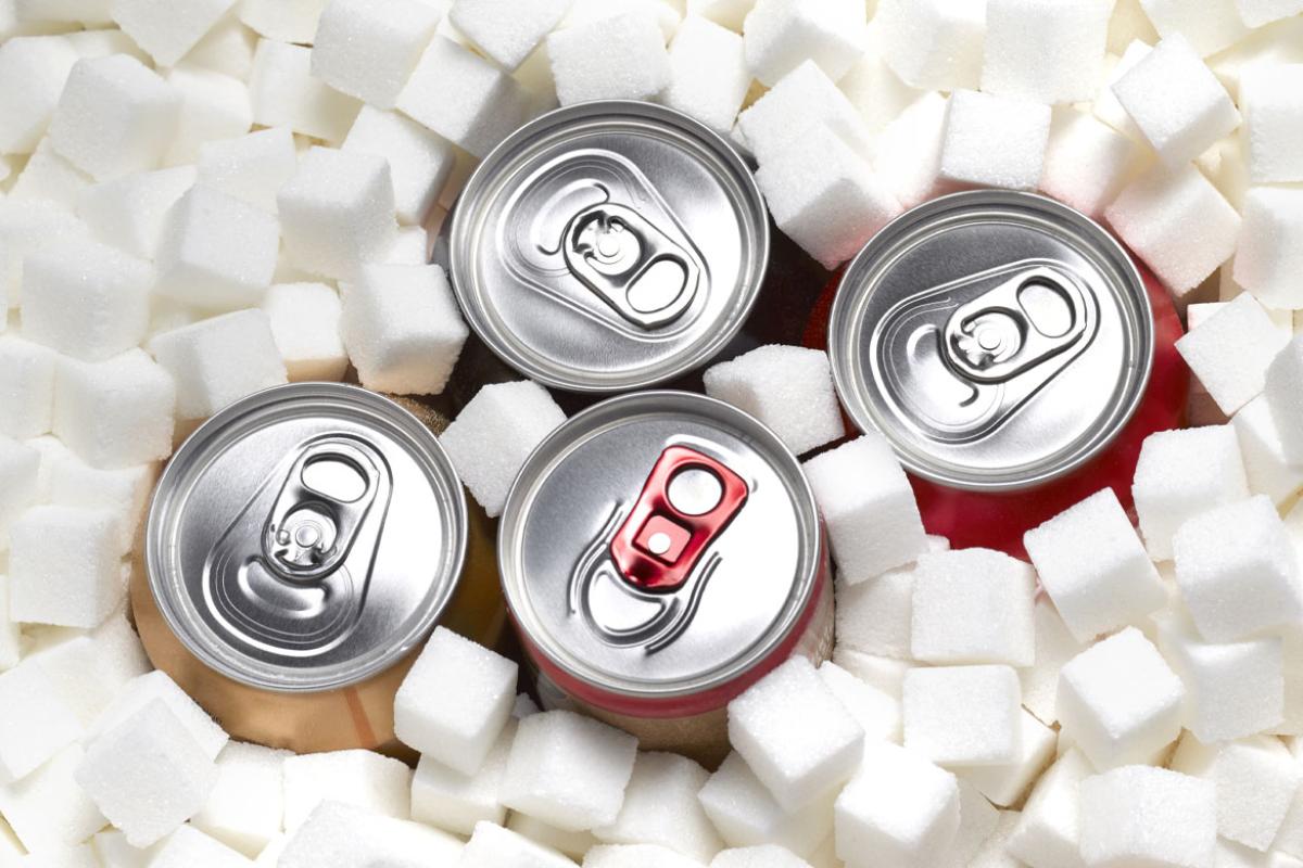 The tops of four aluminum pop-top cans, surrounded by sugar cubes. 