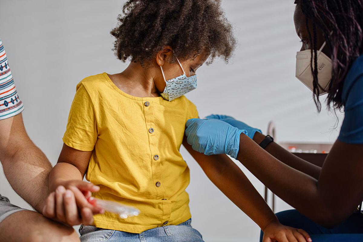 Young child looking at arm after receiving vaccine