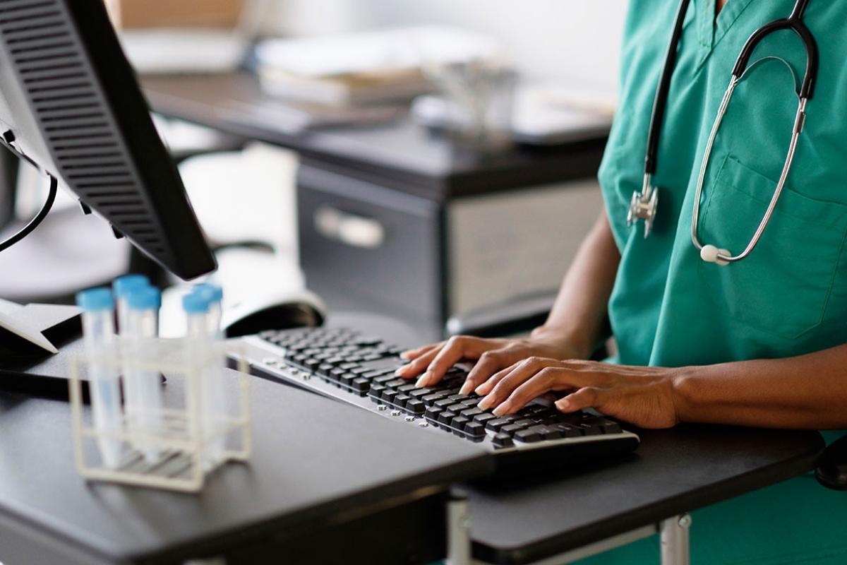 Health care worker typing on a keyboard