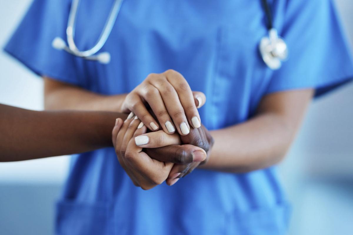  Health care worker holding a patient's hand
