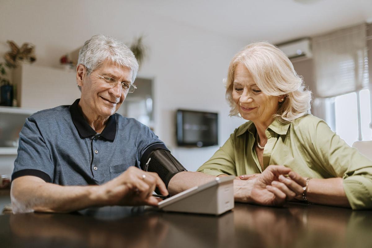 Senior couple taking blood pressure at home