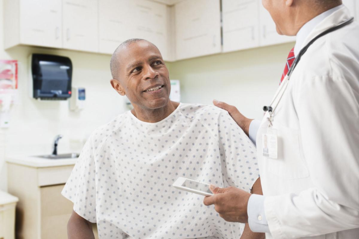 Smiling patient with physician's hand on his shoulder