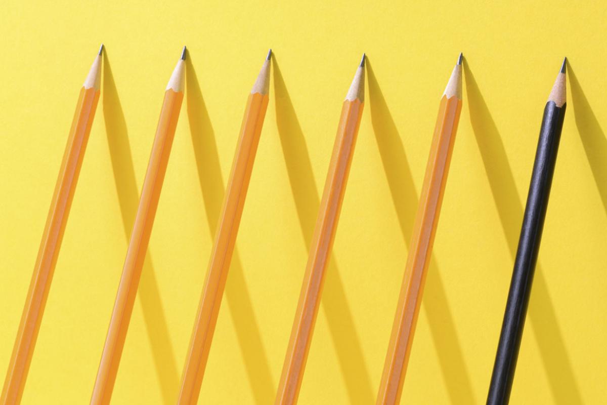 A row of pencils lined up on a wall