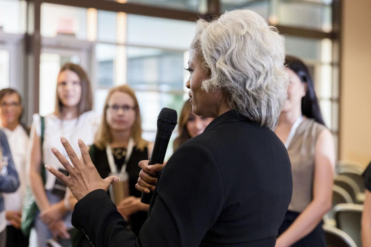 Person gestures while speaking to a crowd of people