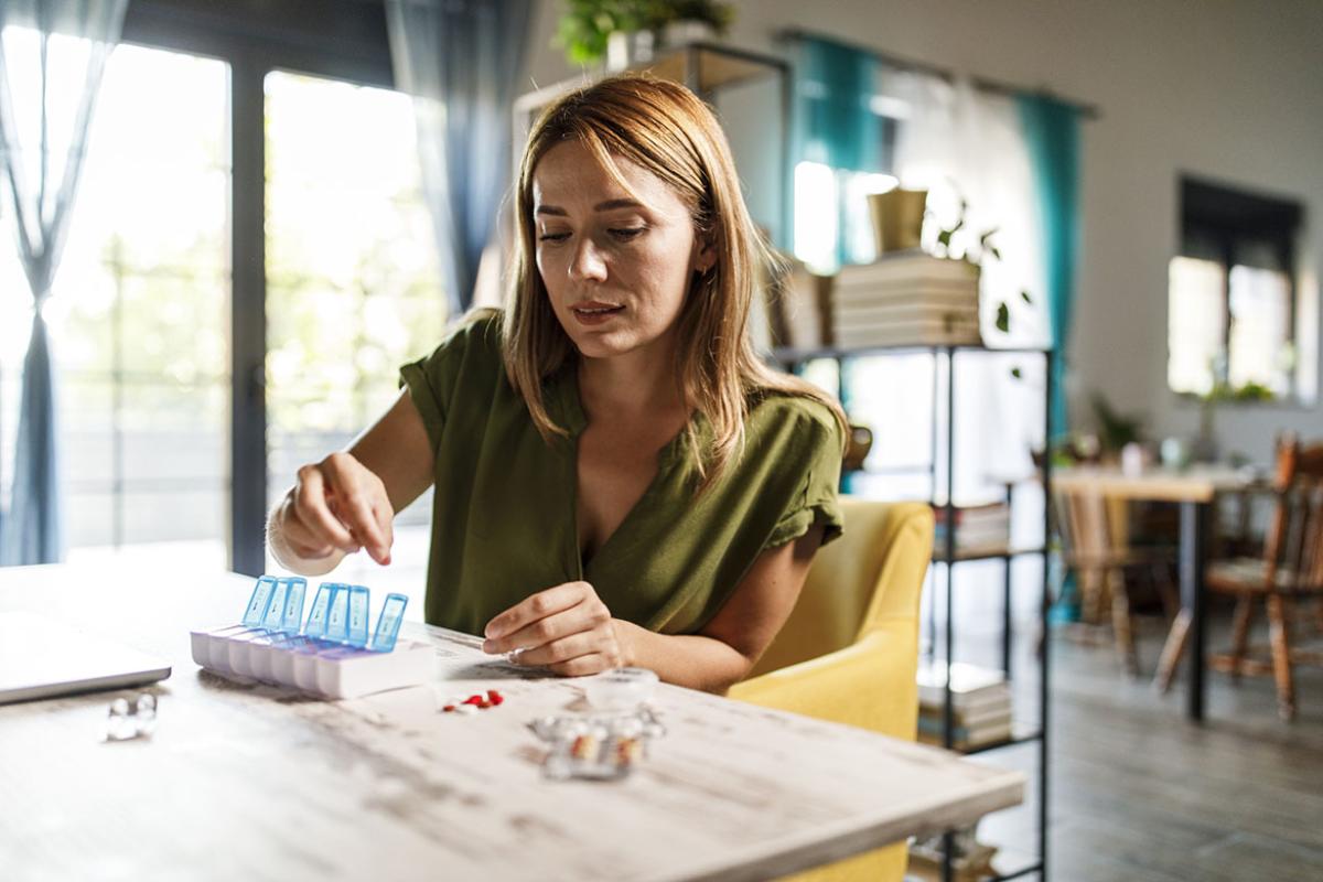 Woman sorting her medication in pill organizer