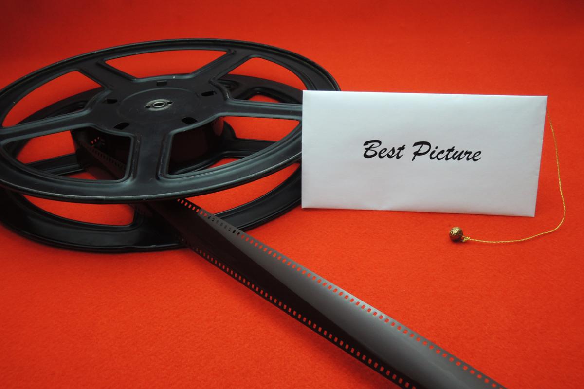 Film reel with Best Picture envelope laying atop it.