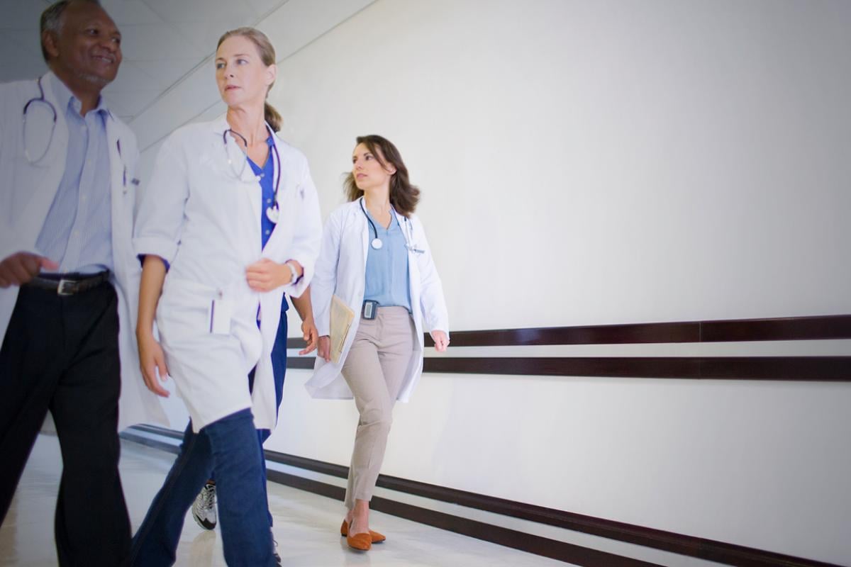 Four physicians walking down a hallway. 