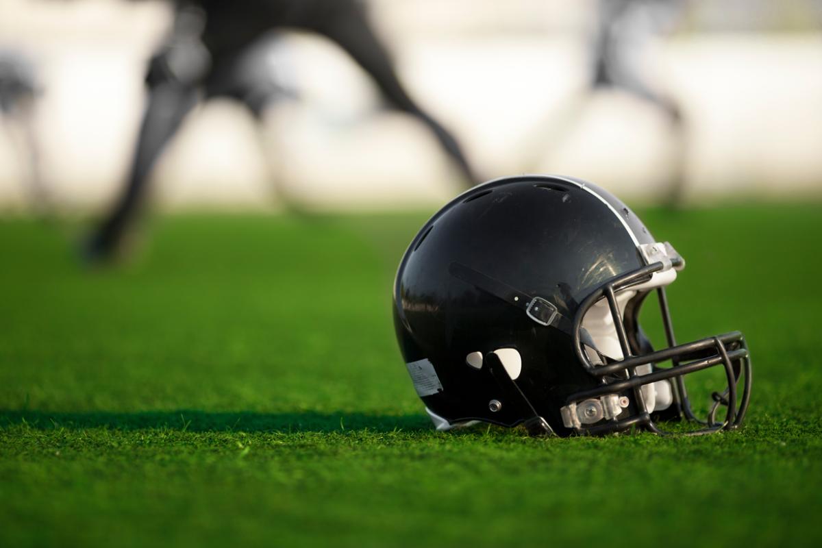 Football helmet resting on a football field. 