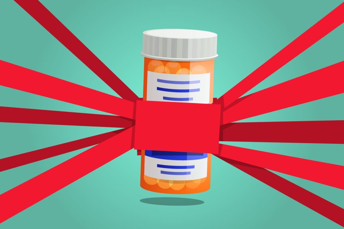 A prescription pill bottle with red tape to it in every direction.
