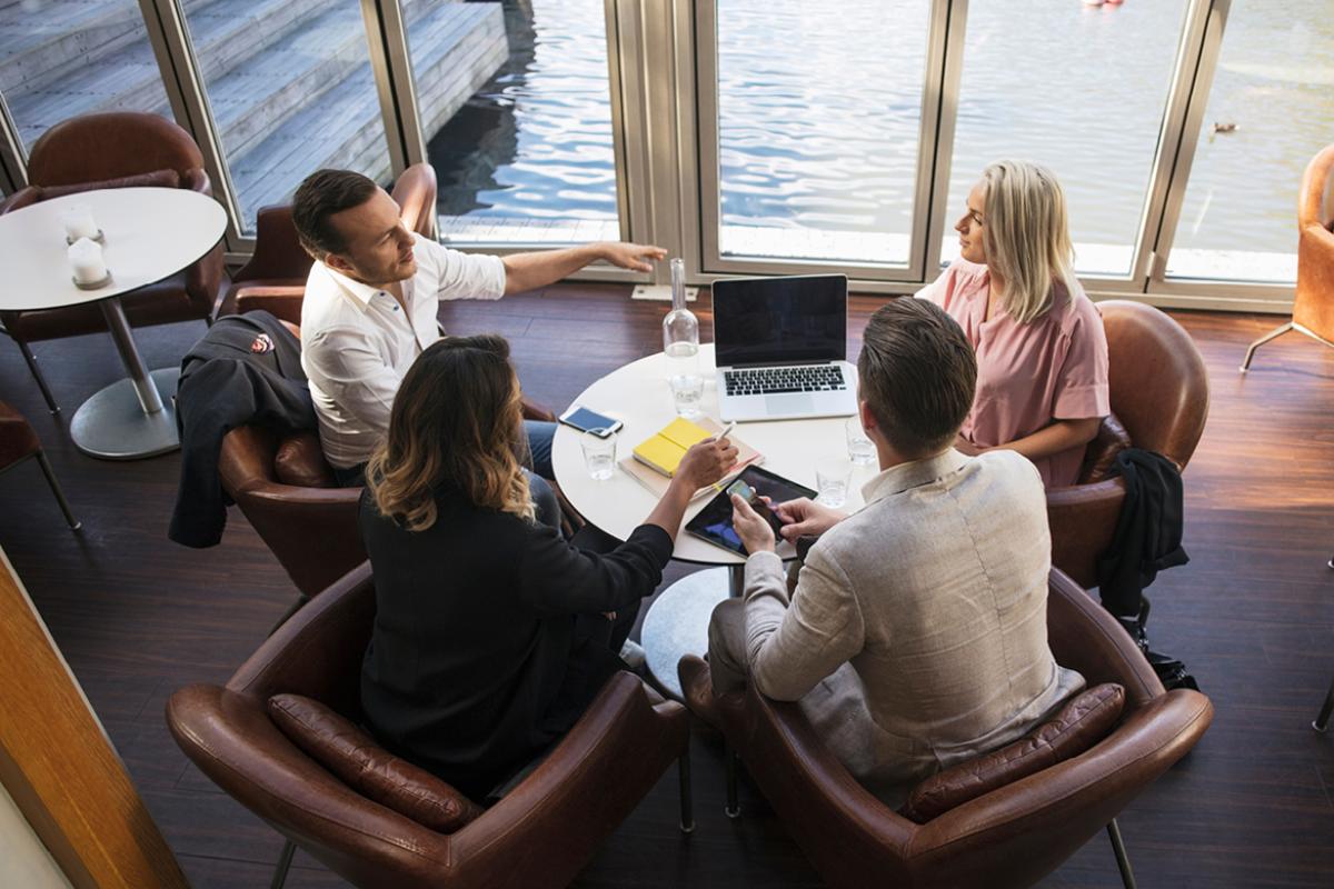 A diverse group of medical professionals meeting around a circle table. 