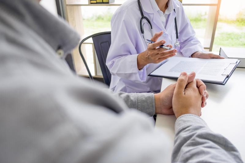 Midsection of physician and patient speaking in an office