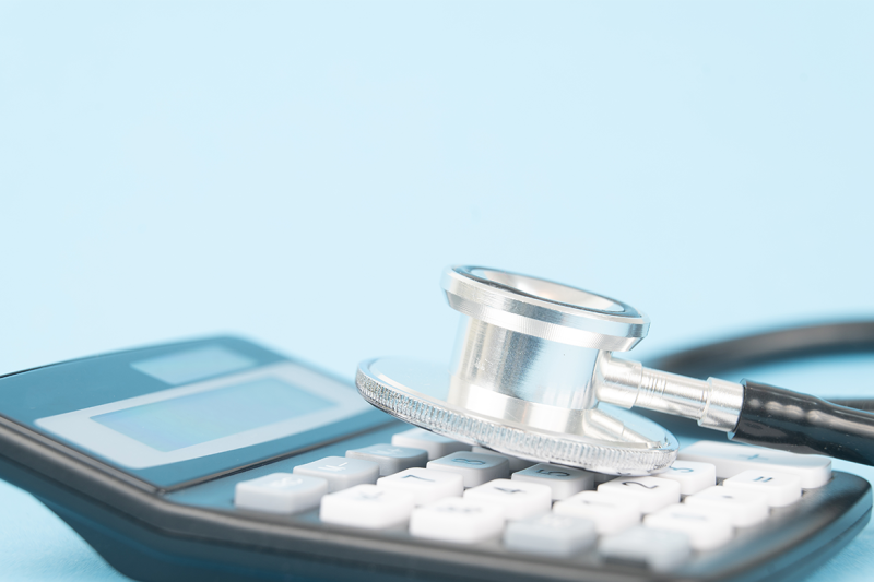 Calculator and stethoscope on a desk