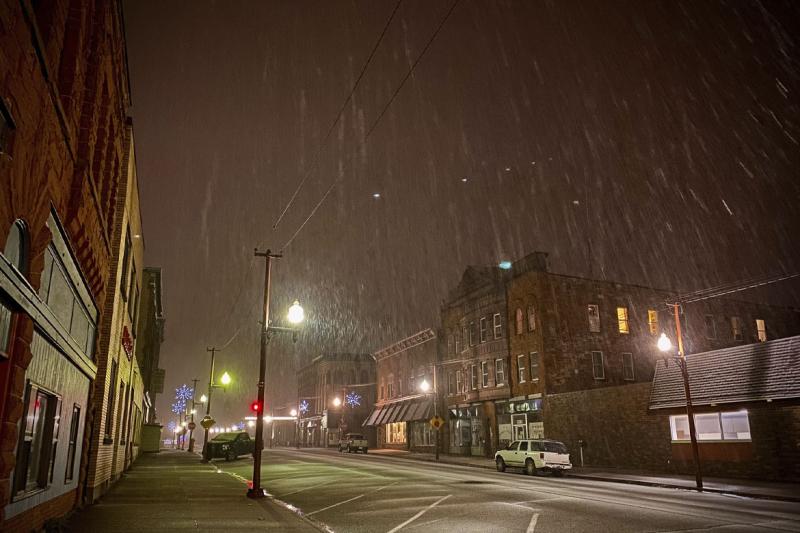 Empty, small town street at night in snow storm